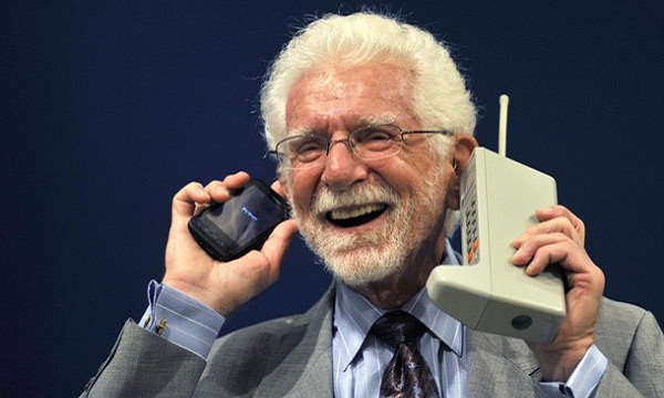 Martin Cooper drži Motorolu DynaTAC, prvi komercijalni mobilni telefon. Izvor: Motorola Mag